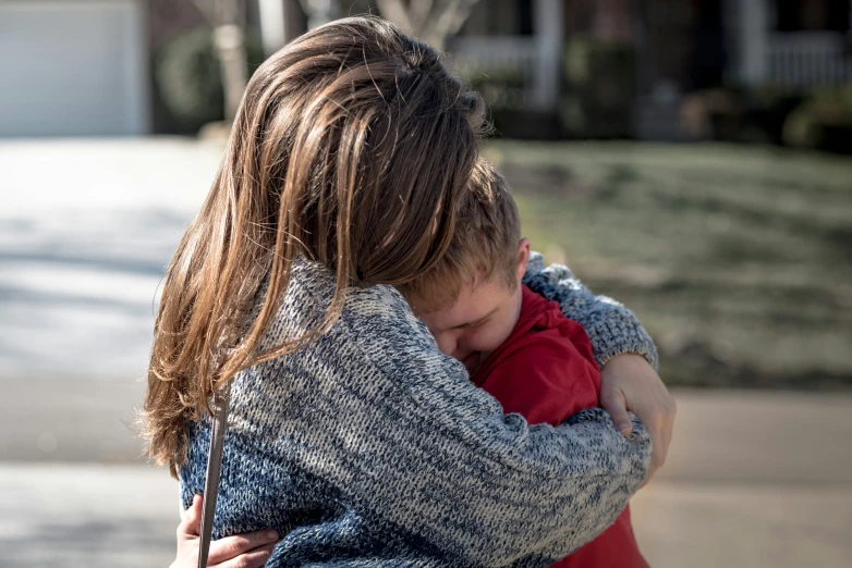 a young person holding onto the shoulders of another child