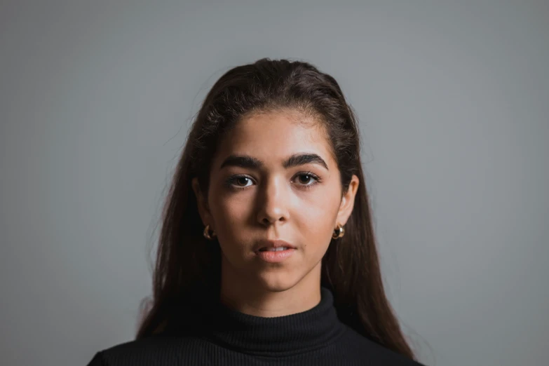 a woman with long hair in front of grey background