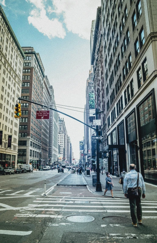 two people crossing the street at a crosswalk with buildings in the background