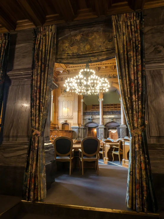 an ornate room with chandelier and curtains