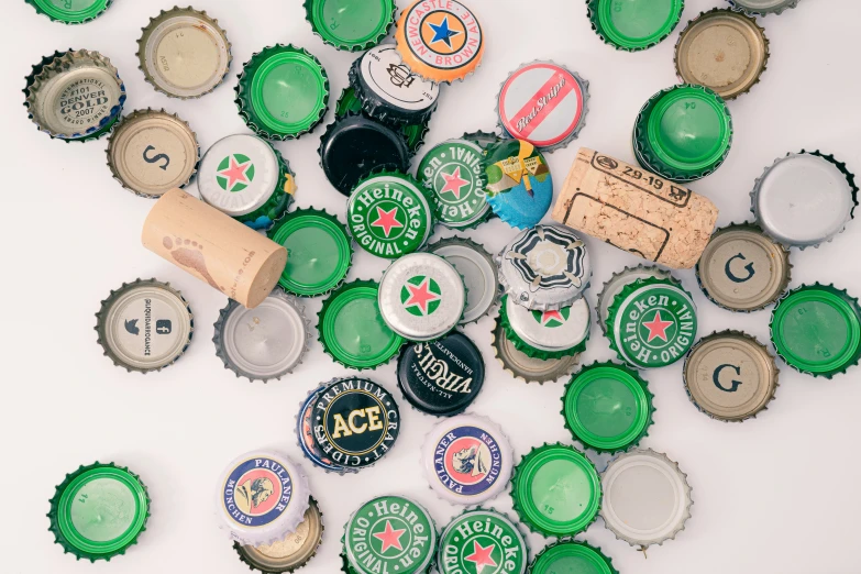 many small soda bottle caps laid out on a white surface