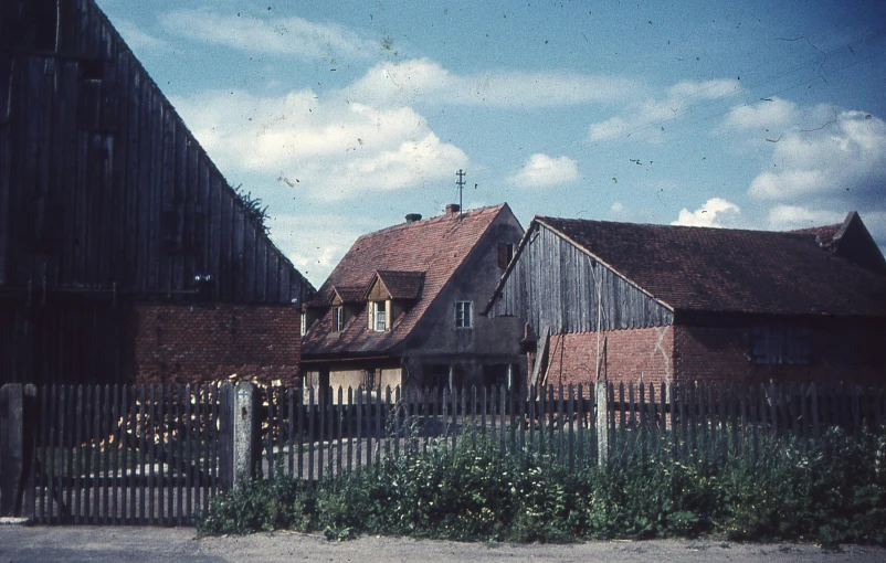 a large wooden house with a small fence