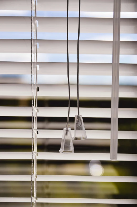 light bulbs suspended from white and black blind with blinds