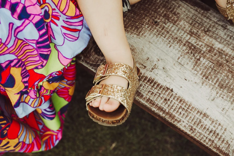 a close up s of someone wearing sandals and a dress