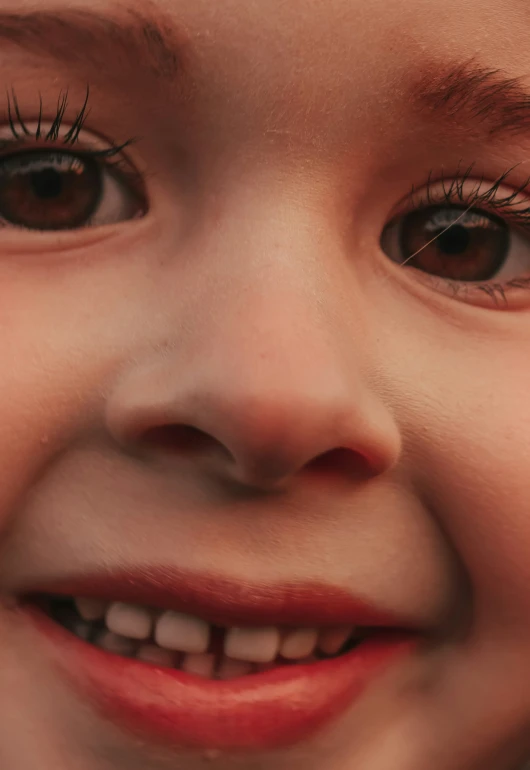 a child has long eyelashes on her brown eyes