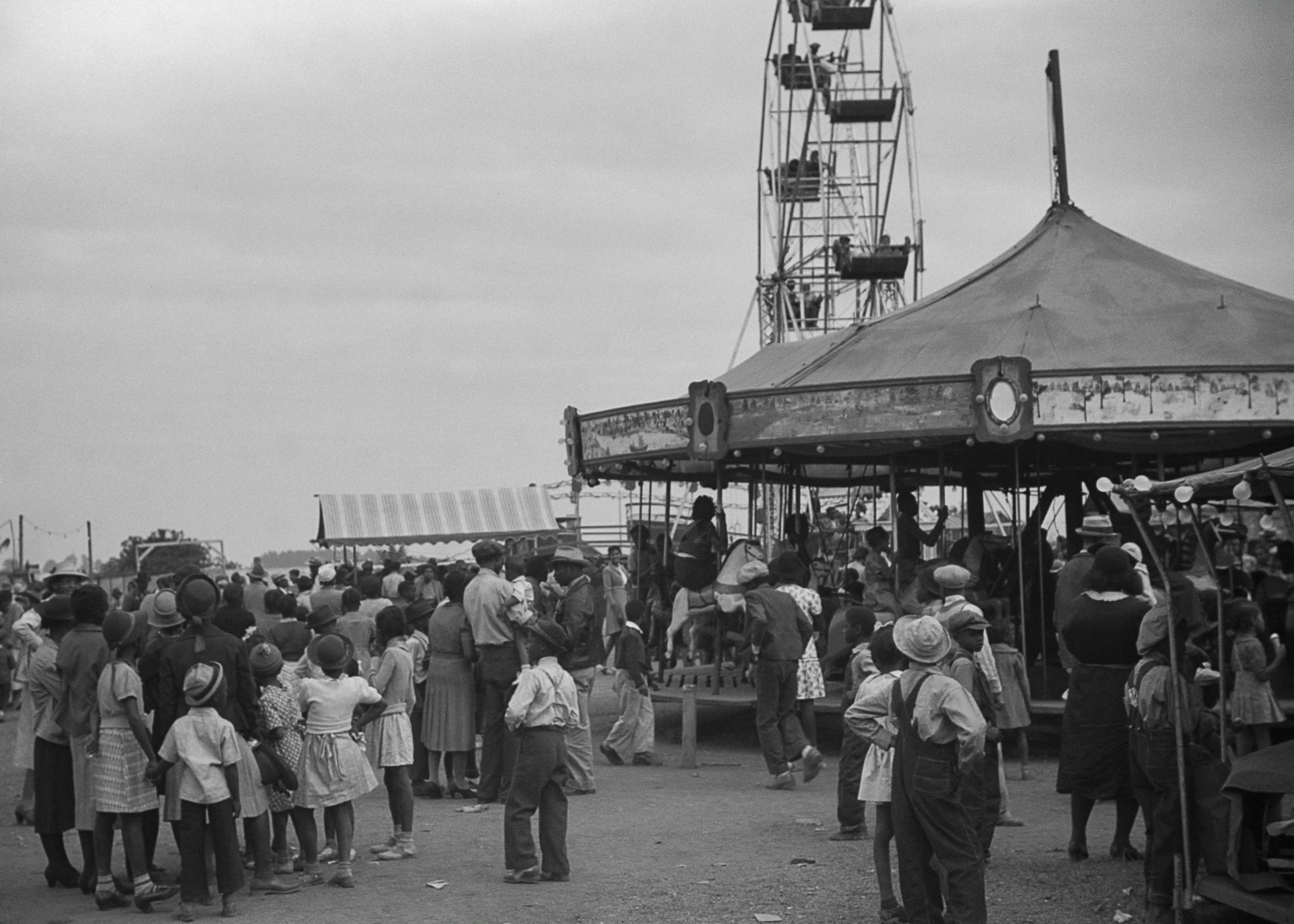 a group of people standing around a carnival ride