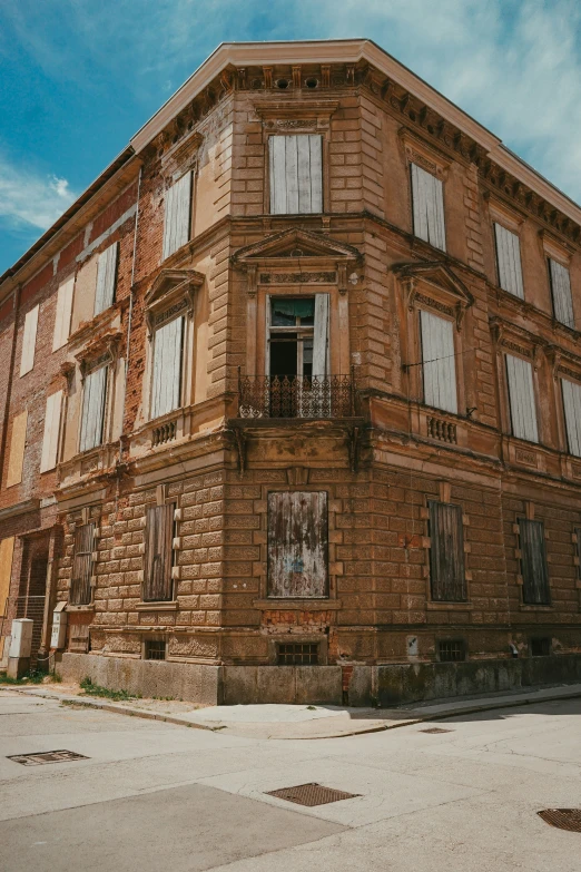 old brown building with balconies sitting in an empty area