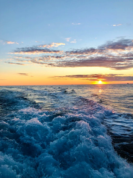 a sunset on the ocean over a body of water