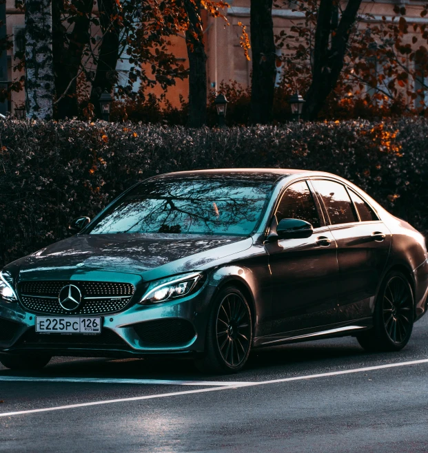 a mercedes c coupe parked on the road with a green paint job