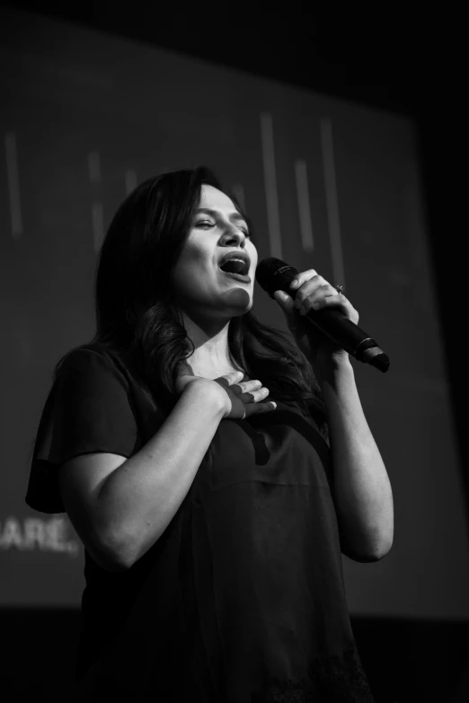 a woman is performing in front of a crowd