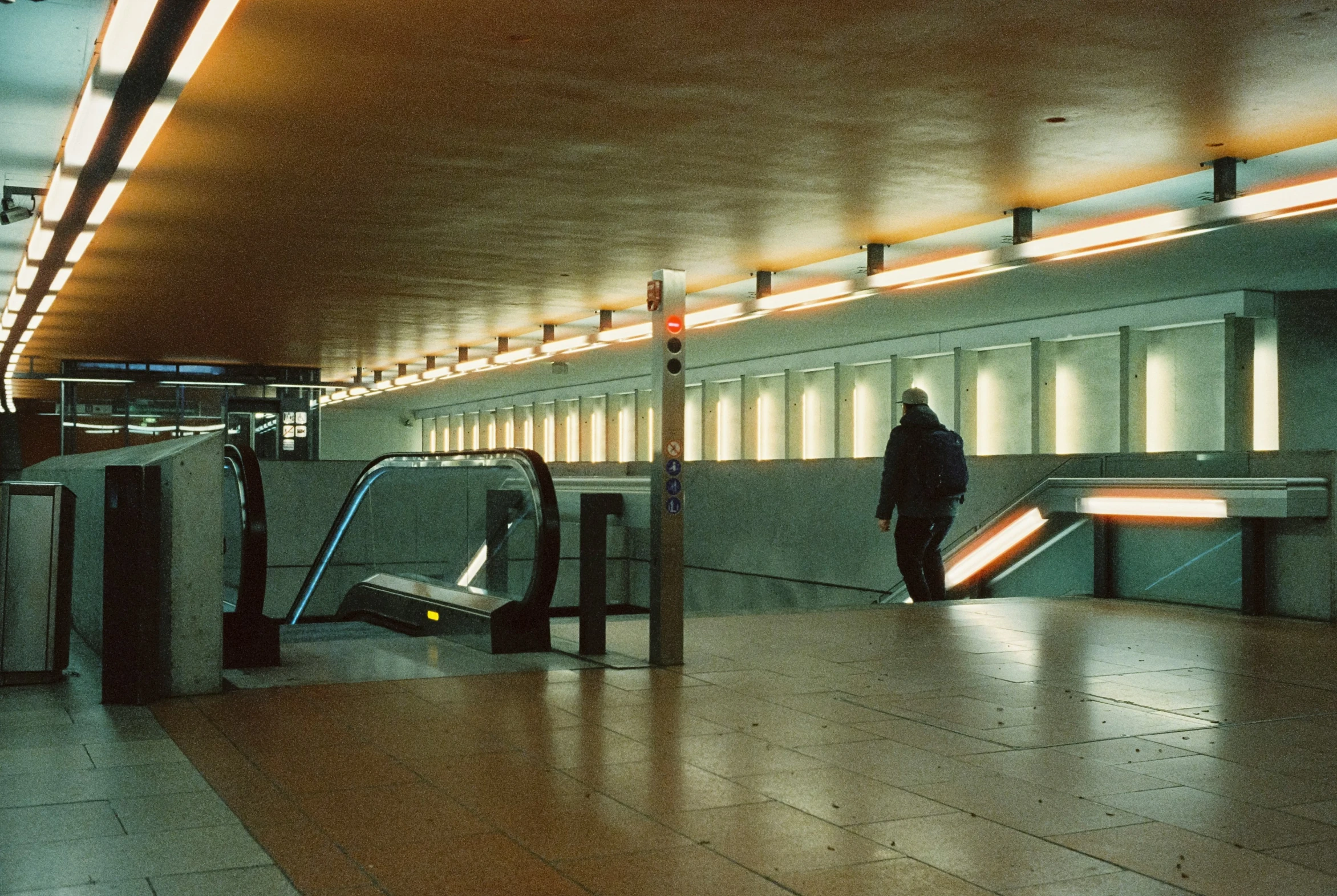 a subway station with people waiting on the escalator