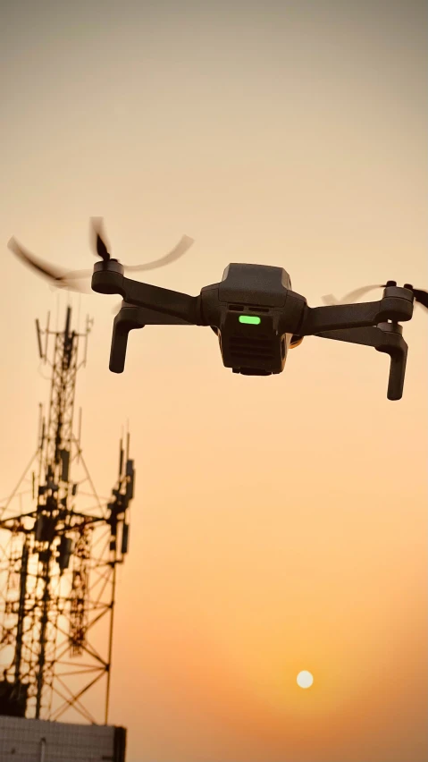 a helicopter flying in the air over a radio tower