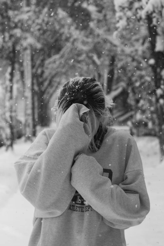 an image of a woman covering her eyes outside in the snow