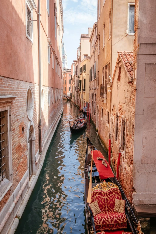 a small canal with boats moving through a city