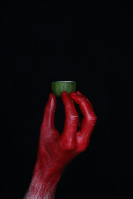 the hand holds a mug that is red and green