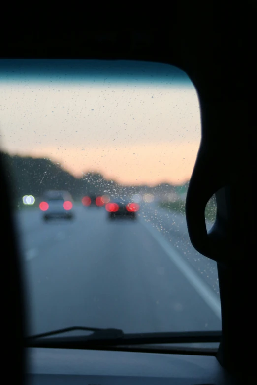 an image of traffic from the windshield during sunset