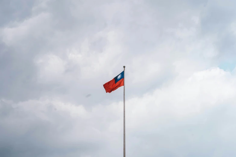 an old - fashioned flag flies in a wind with a blue and red cross on it