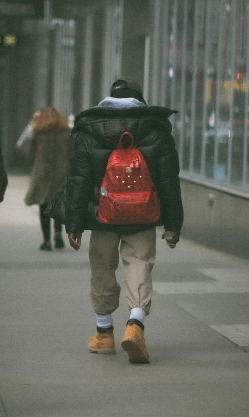 a person with a backpack is walking down the street