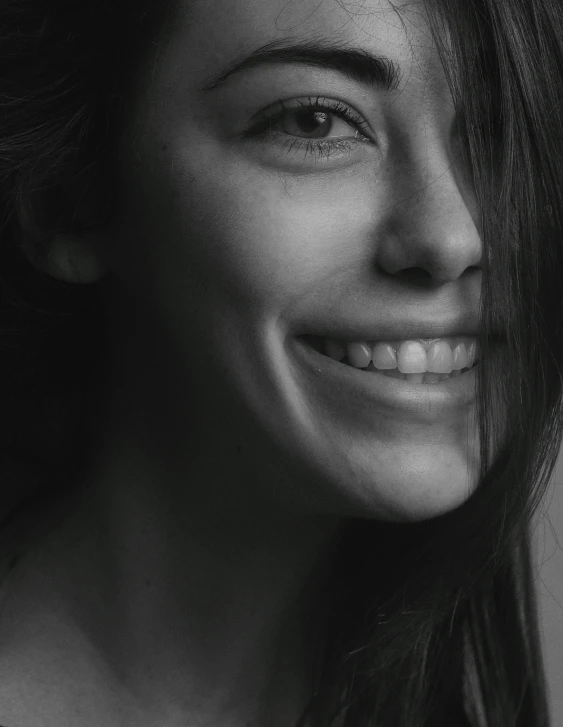 black and white image of smiling woman with long hair