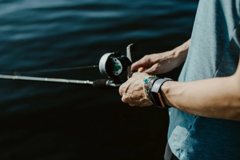 a man holding a fishing rod on a river