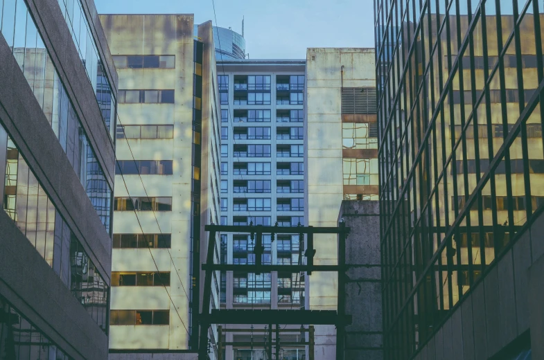 looking up at tall buildings and a metal rail on the sidewalk