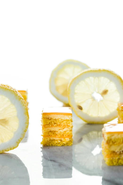 a lemon cake with slices cut out, in front of a white background