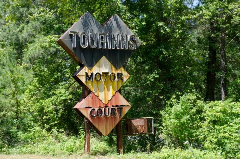 a sign for a motor court with graffiti on it