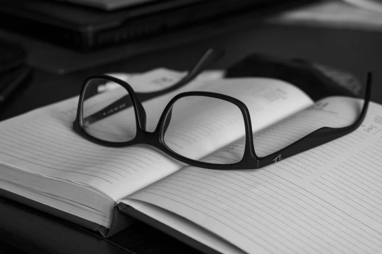 a book with black glasses sitting on top of it