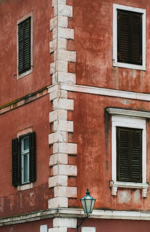 the corner of an old red brick building with windows