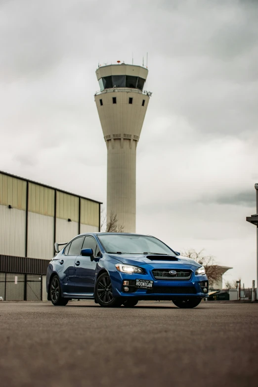 a blue subarunt parked in front of a terminal