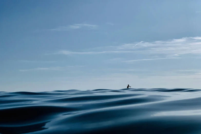 there is a lone person in the distance in the middle of the water