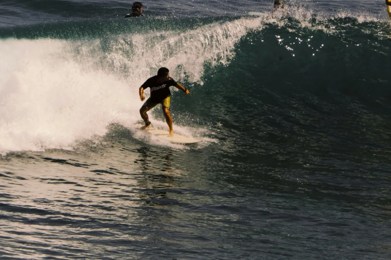 a man riding a wave on top of a surfboard