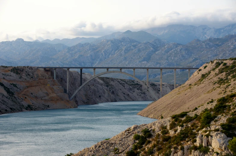 a bridge over the water leading to mountains