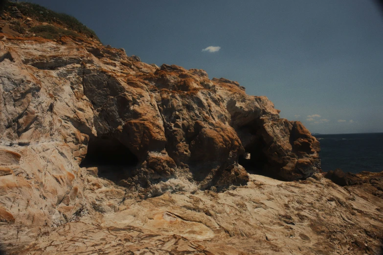 this rock formation has a dark, hollow opening in the top