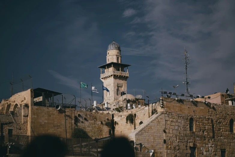 the bell tower of a large building is on a hill