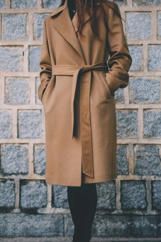 a person standing in front of a brick wall