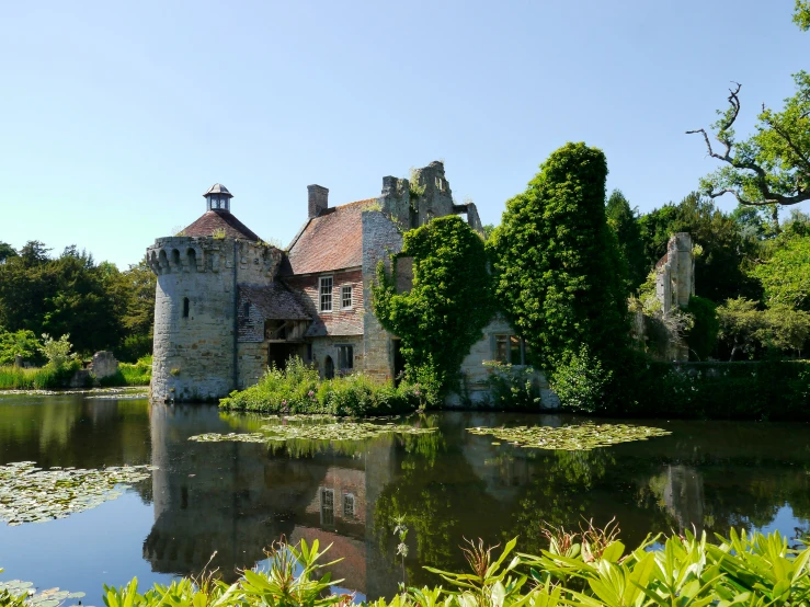 an old castle stands next to a river