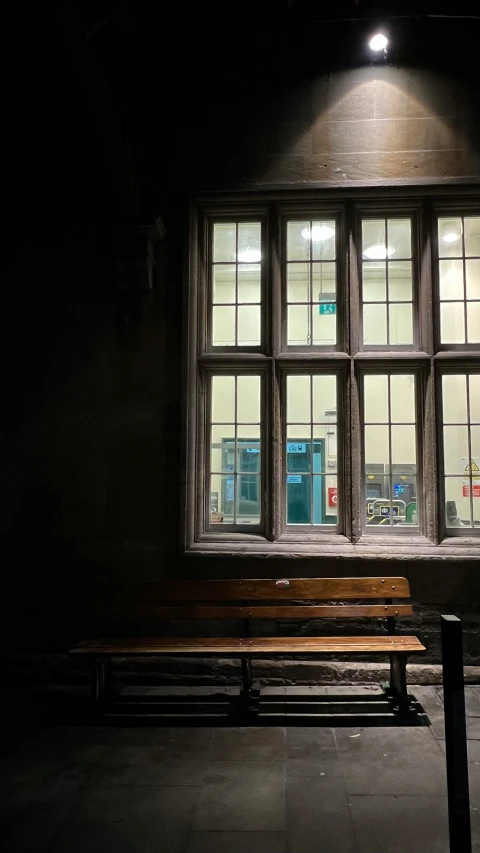 a po of an empty public bench in a dark lit room