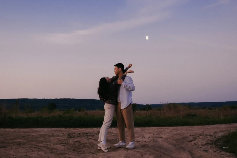 two women in a desert clearing in front of an overcast sky