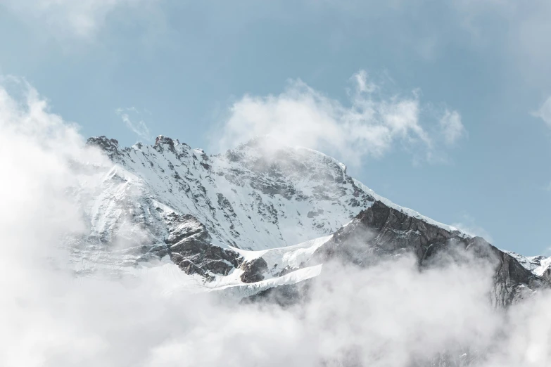 the top of a mountain, shrouded in clouds