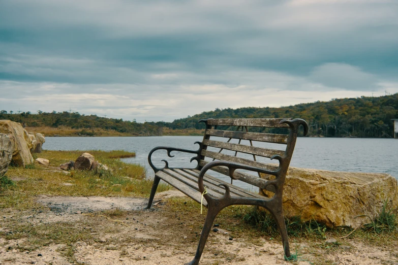 an empty park bench near the water