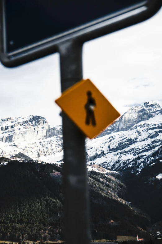 a sign showing a pedestrian crossing in the mountains