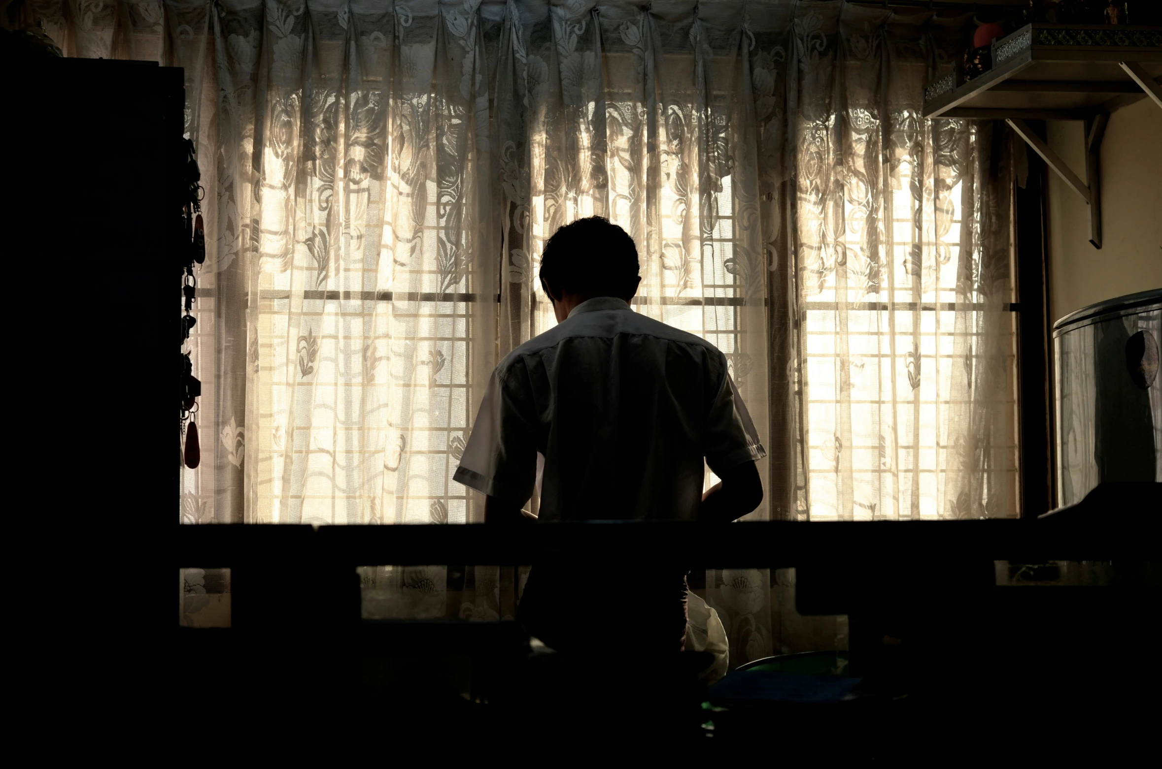 a man standing in front of a window in the dark