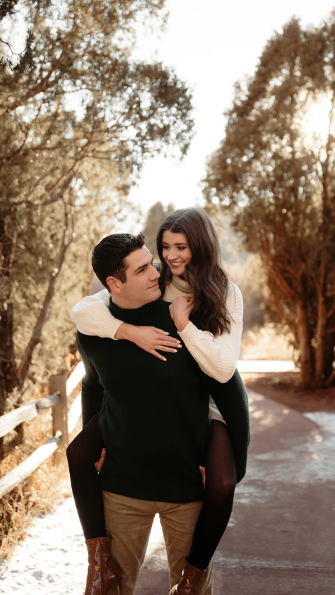 an engaged couple is holding each other by the water