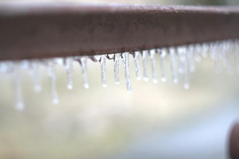 a line of water droplets on top of a wooden bench