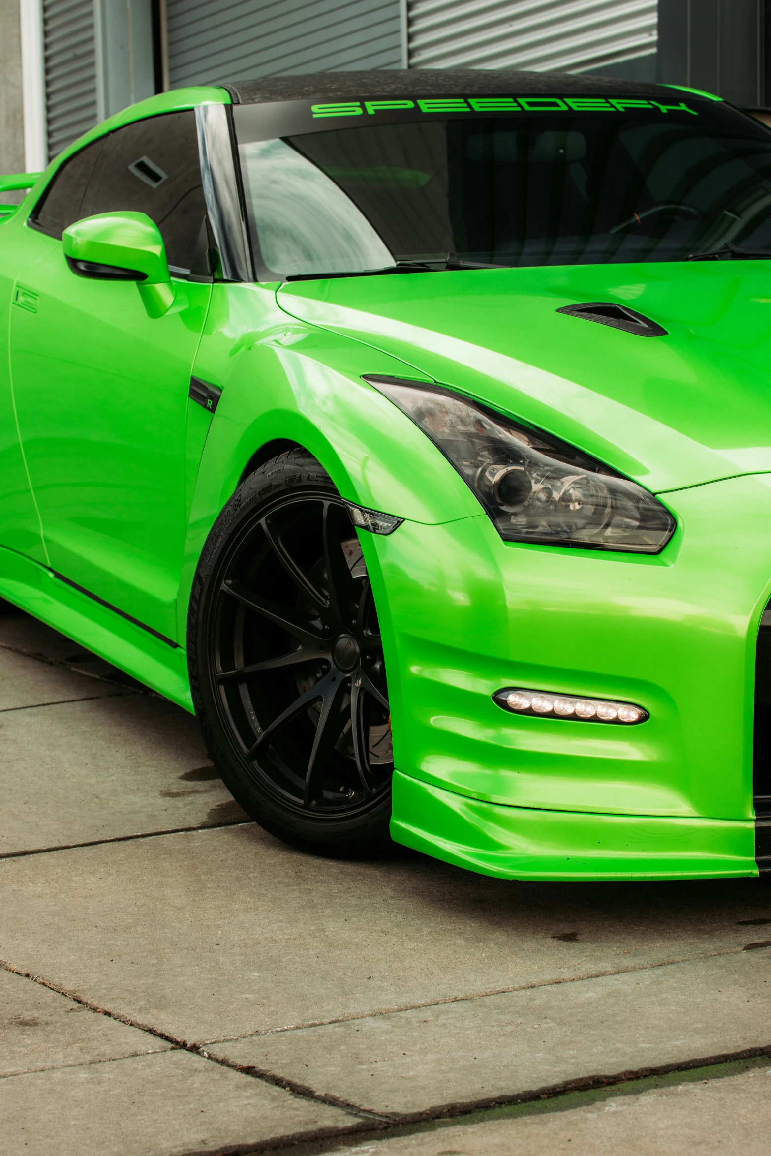 a green sports car with a front bumper