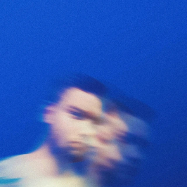 man with blurry image of head against a blue background