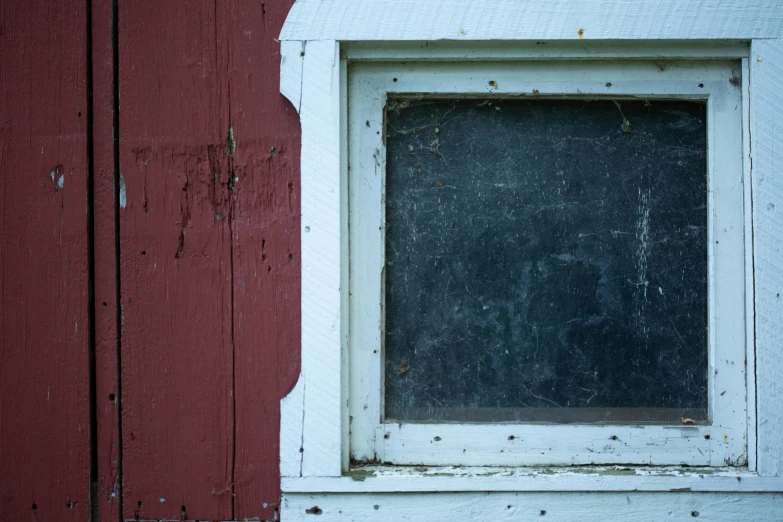 a window is open in an old red wall