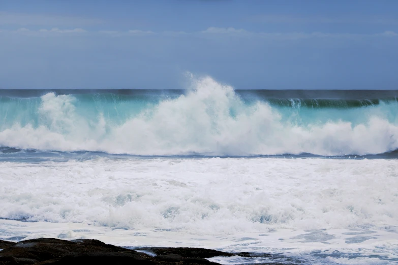 a very big wave in the ocean crashing over it