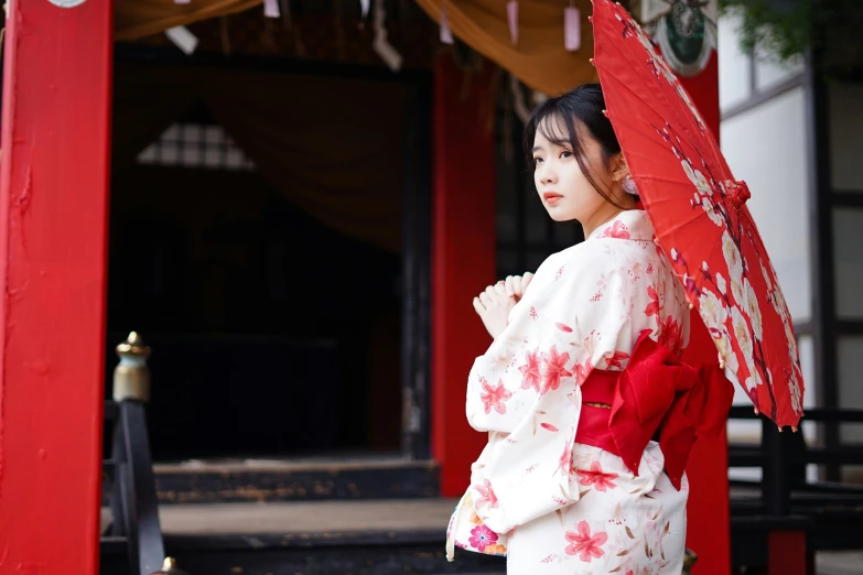 a woman in traditional japanese dress holding a red umbrella